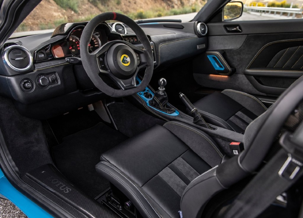 The black-leather-and-Alcantara-clad front seats and dashboard of a blue 2020 Lotus Evora GT