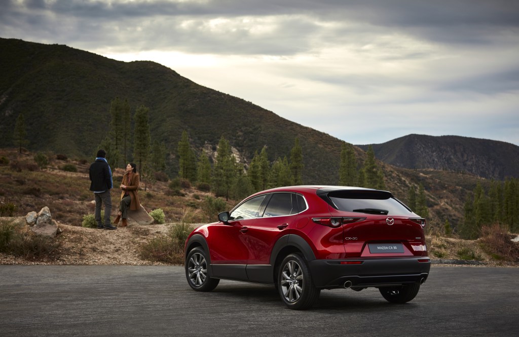 A red 2020 Mazda CX-30 parked, looking toward a mountain range