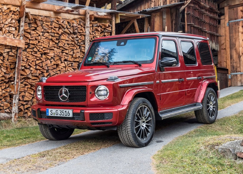 A red 2020 Mercedes-Benz G350d in front of an old wooden building
