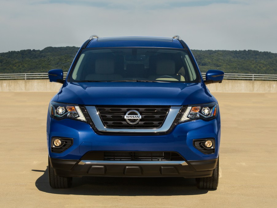 Front view of a blue 2020 Nissan Pathfinder parked on concrete in front of a mountain