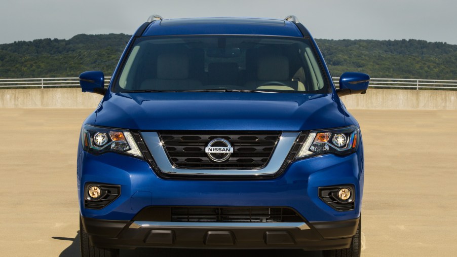Front view of a blue 2020 Nissan Pathfinder parked on concrete in front of a mountain
