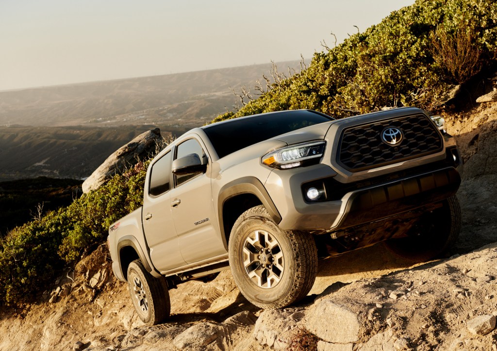 A gray 2020 Toyota Tacoma TRD Off-Road four-door pickup truck traversing rocky terrain on a mountainside