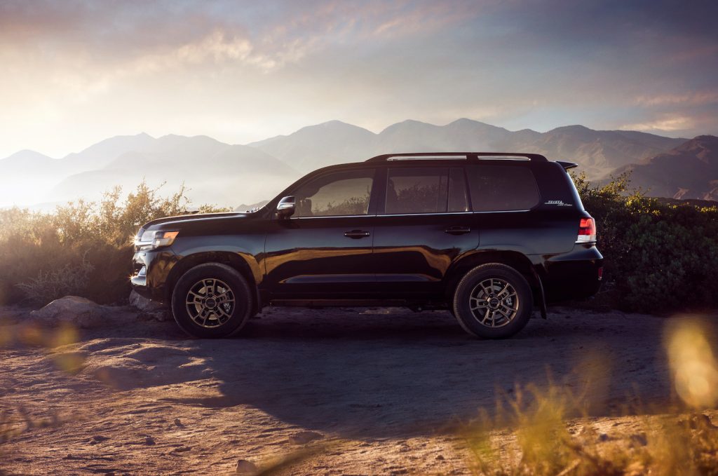 The Toyota Land Cruiser parked in front of a mountain range.