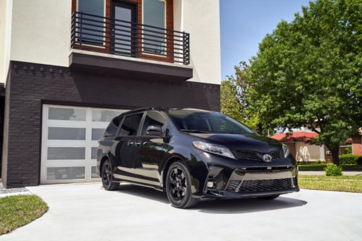 A black Toyota Sienna minivan parked in a driveway.