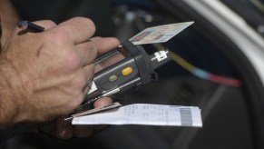 A police officer issues a speeding citation using a e-citation machine in 2020