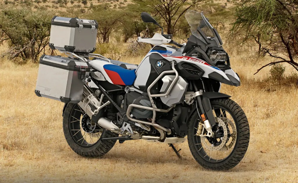 A white-blue-and-red 2021 BMW R 1250 GS Adventure in the brush with accessory luggage