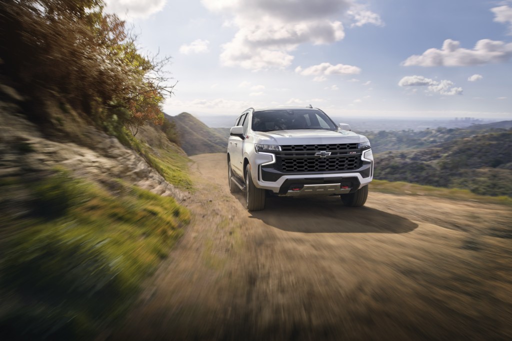 A front-facing look at a white 2021 Chevy Tahoe Z71 driving down a dirt road