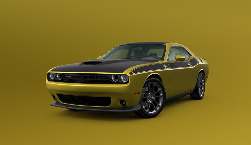 A gold and black 2021 Dodge Challenger T/A on display in front of a gold background