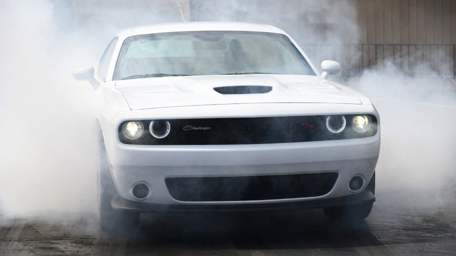 A white 2021 Dodge Challenger R/T Scat Pack 1320 does a burnout that creates smoke from the tires