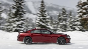 A red 2021 Dodge Charger GT AWD driving through the snow