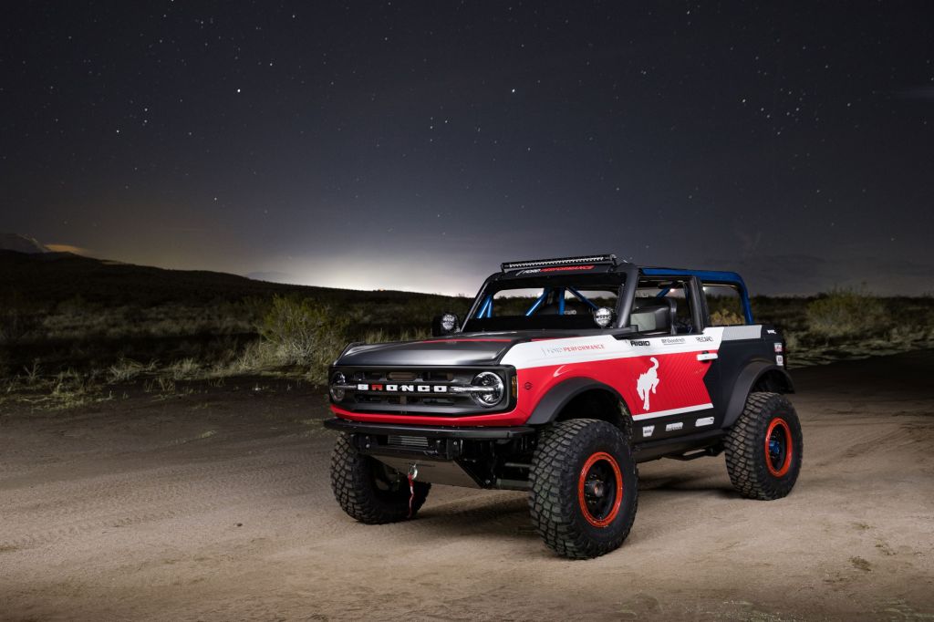 The red-white-and-blue 2021 Ford Bronco 4600 racer in the desert at night