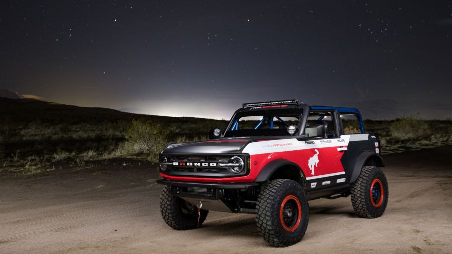 The red-white-and-blue 2021 Ford Bronco 4600 racer in the desert at night