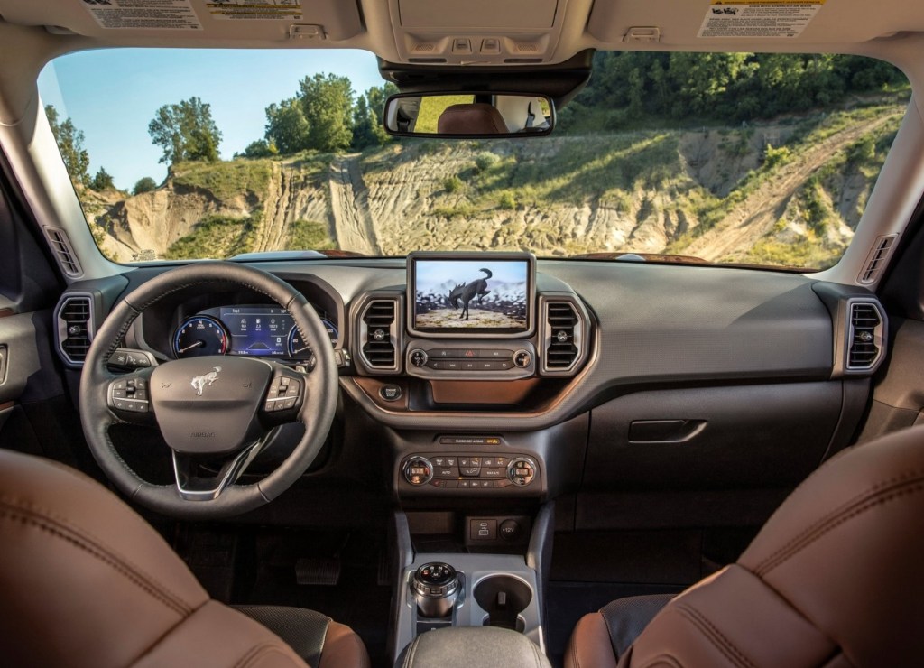 The brown-leather-lined front seats and gray dashboard of the 2021 Ford Bronco Sport Badlands with the Badlands Package
