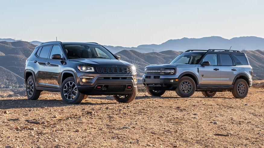 A 2021 Jeep Compass and 2021 Ford Bronco parked in sand near each other 
