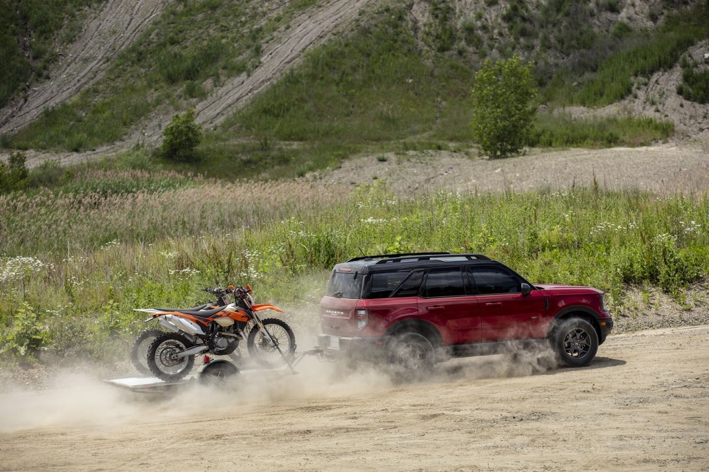 A red 2021 Ford Bronco Sport towing a pair of dirt bikes