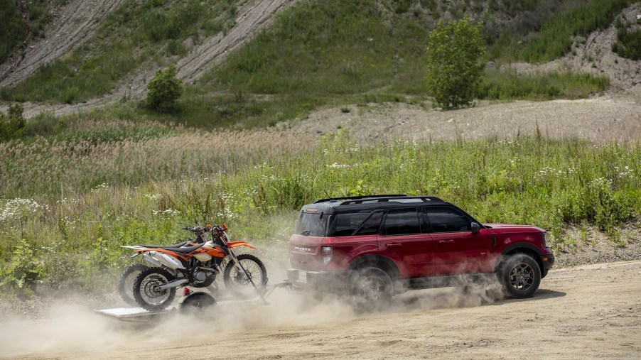 A red 2021 Ford Bronco Sport towing a pair of dirt bikes