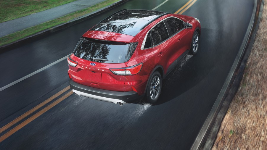 An overhead shot of a red 2021 Ford Escape SEL EcoBoost compact crossover SUV traveling on a wet road