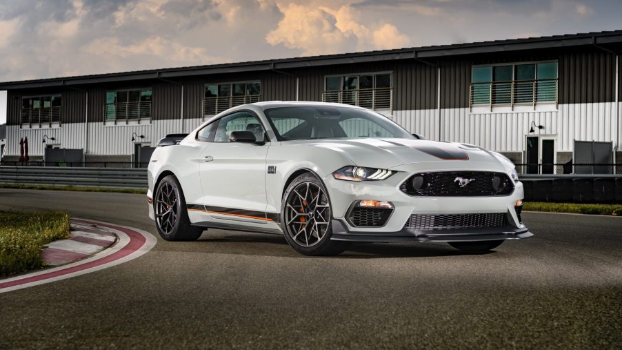 A white 2021 Ford Mustang taking a turn on a race track