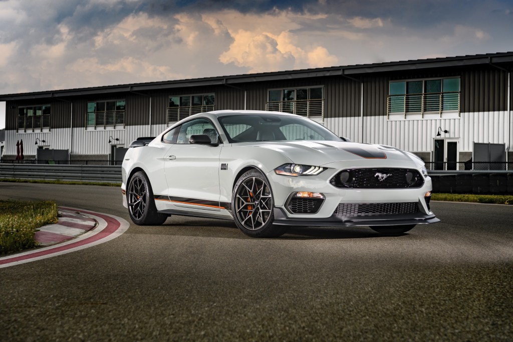 A white 2021 Ford Mustang taking a turn on a race track