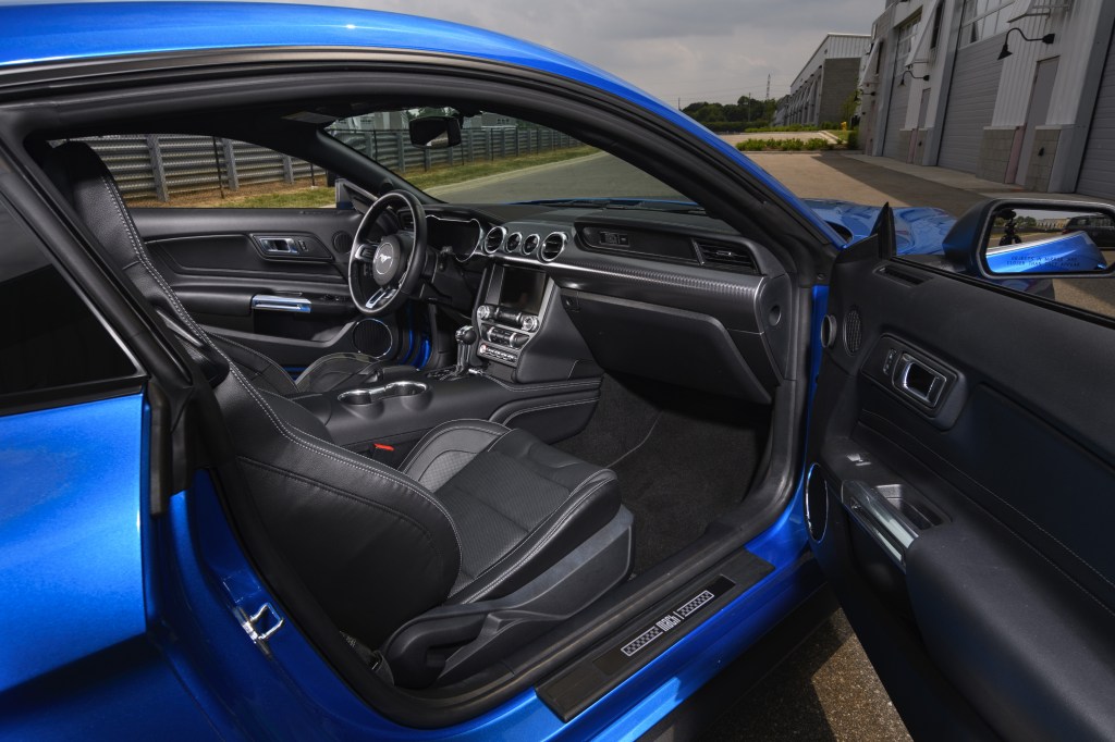 A look into the interior of a blue 2021 Ford Mustang from the passenger-side door.