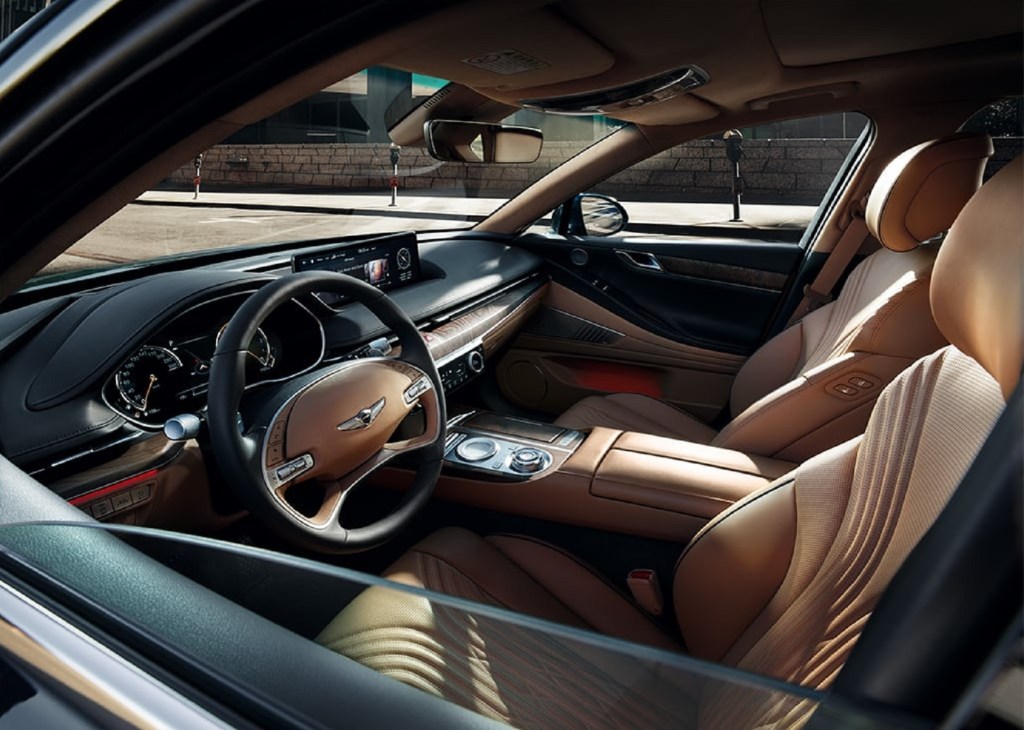 The tan-leather front seats and wood-trimmed dashboard of the 2021 Genesis G80