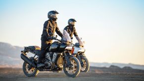 A rider on a black 2021 Harley-Davidson Pan America 1250 in front of an orange 1250 Special in the desert
