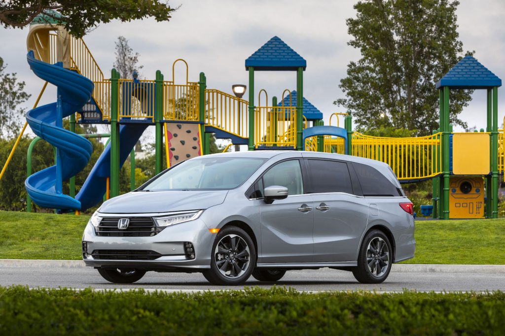 A silver 2021 Honda Odyssey parked in front of a blue and yellow playground
