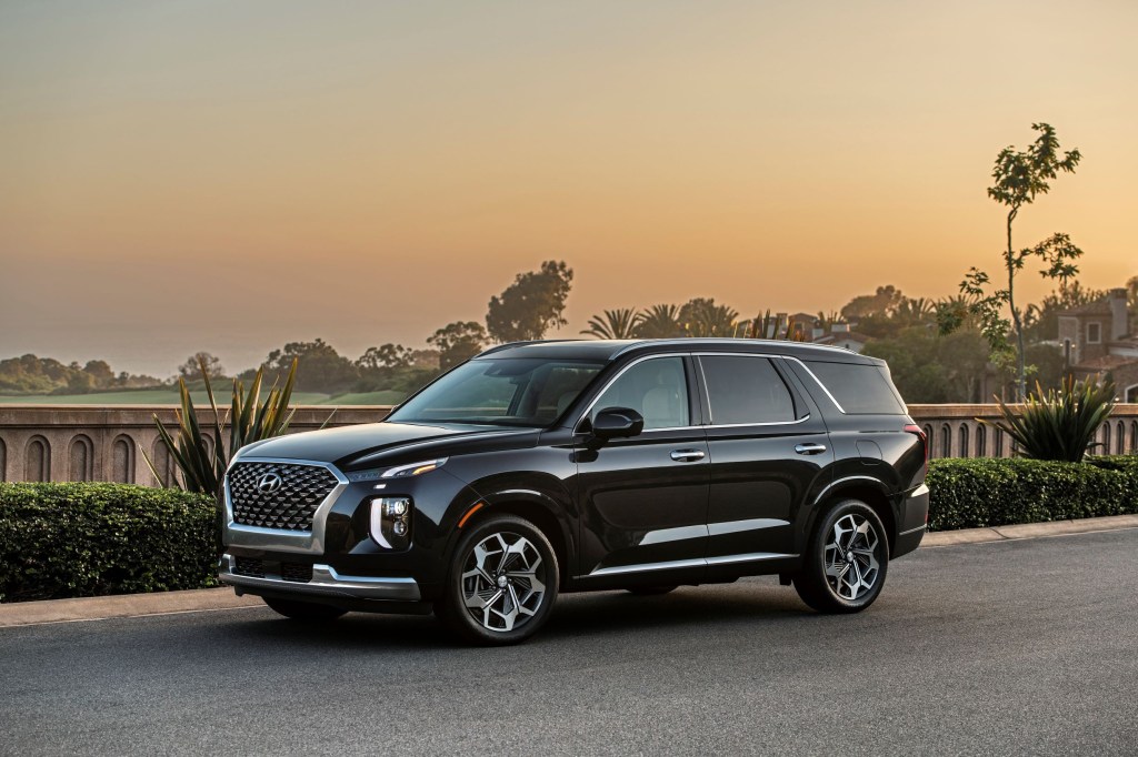 A black 2021 Hyundai Palisade Calligraphy by a sunset lagoon