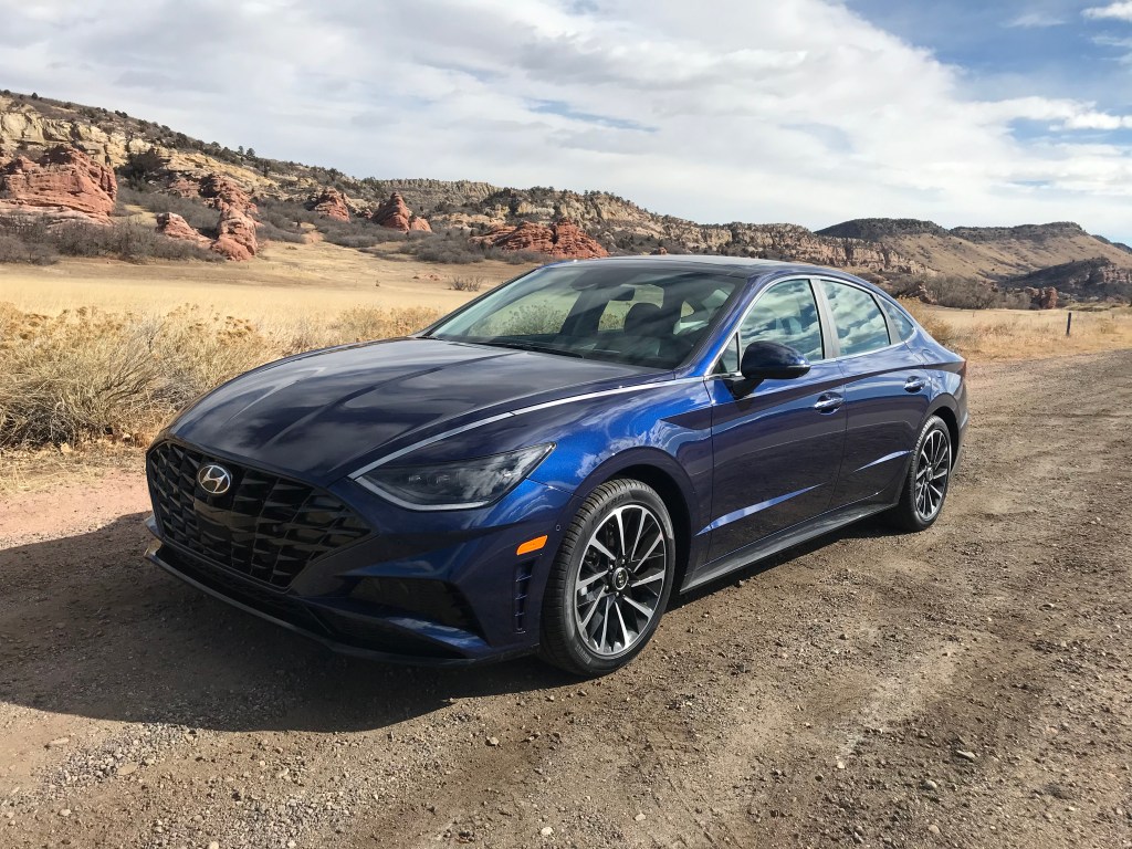 2021 Hyundai Sonata Limited in dark blue parked in the desert with mountains in the background.