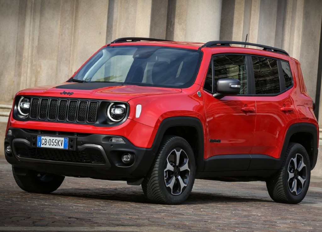 An orange-and-black 2021 Jeep Renegade 4xe by a tan-stone-walled building