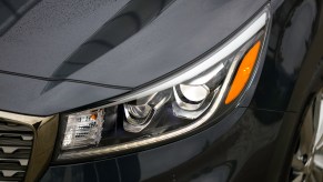 The driver's-side headlight on a dark-colored 2021 Kia Sedona