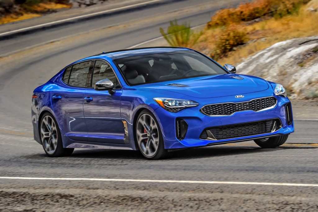 A blue 2021 Kia Stinger GT2 AWD driving down a highway road