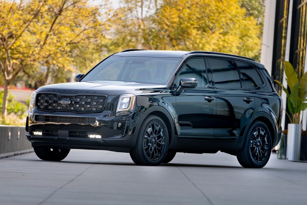 A black 2021 Kia Telluride parked in front of trees