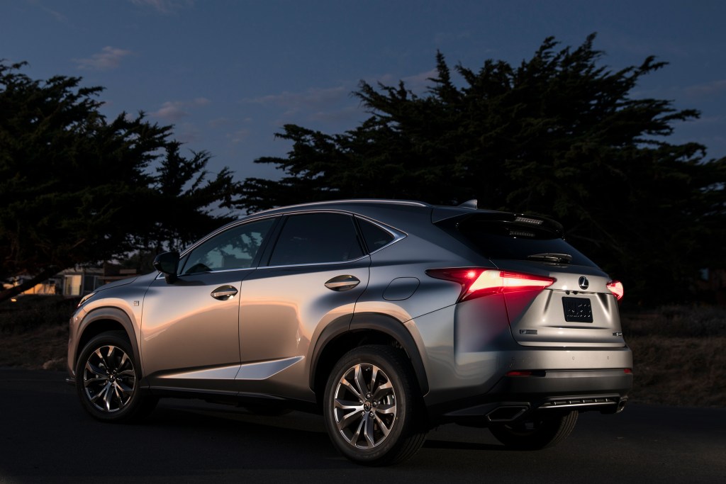 A silver 2021 Lexus NX 300 parked at night with trees in the background