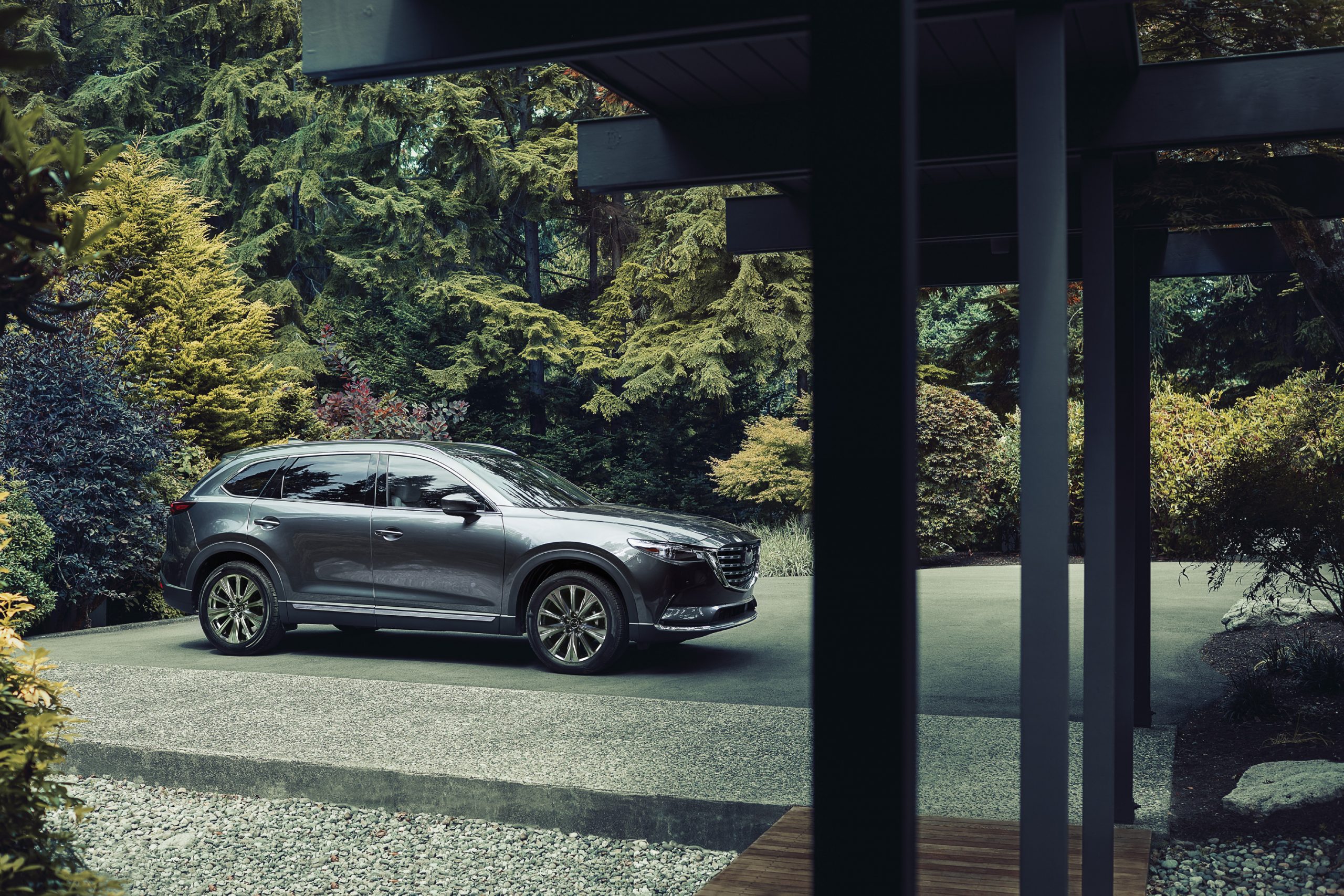 A silver 2021 Mazda CX-9 parked in a driveway with trees in the background