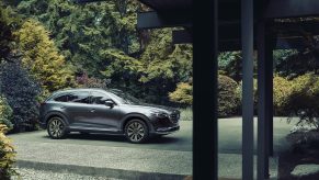 A silver 2021 Mazda CX-9 parked in a driveway with trees in the background
