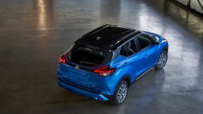 An electric-blue 2021 Nissan Kicks parked in a warehouse