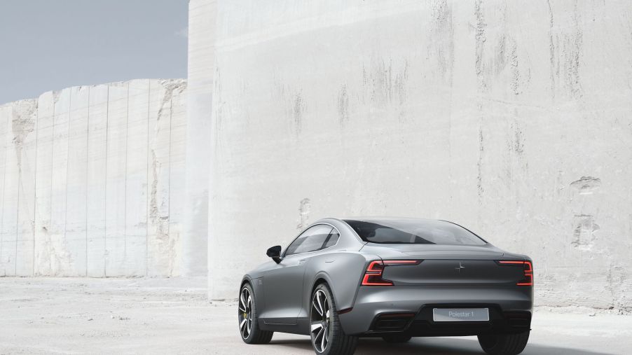 A silver 2021 Polestar 1 coupe parked in front of a whitewashed wall