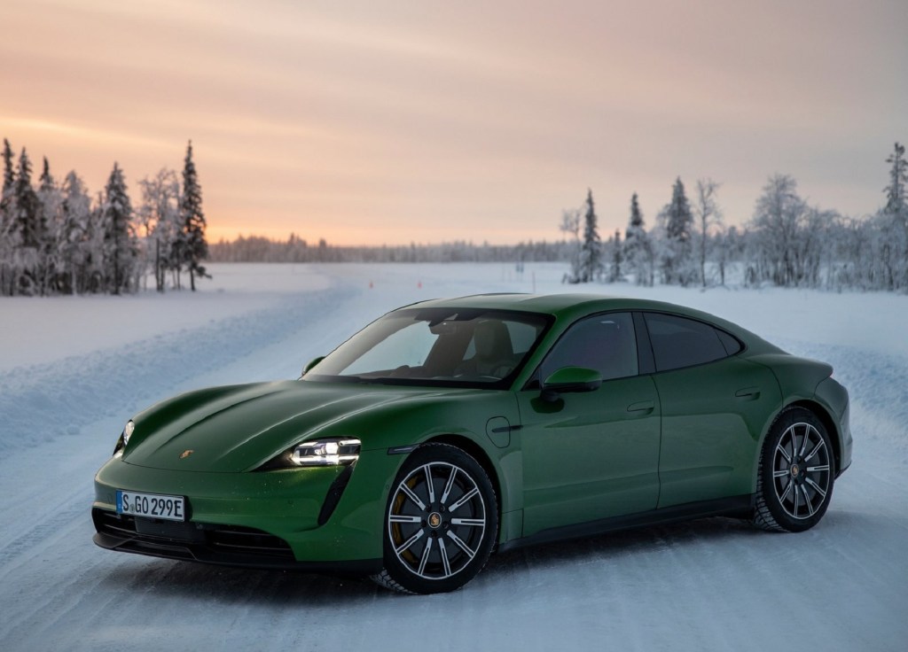 A green 2021 Porsche Taycan 4S in a snow-covered forest