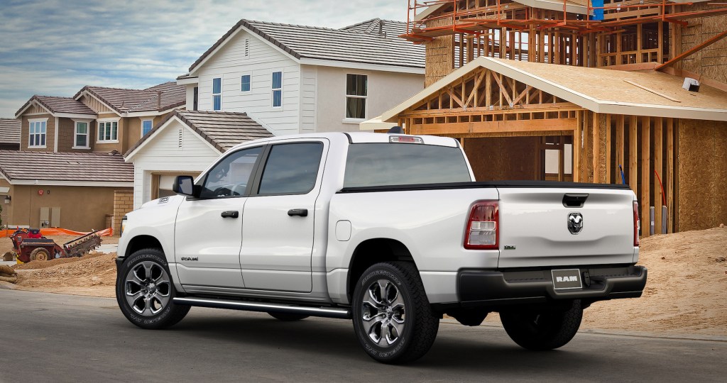 A white 2021 Ram 1500 Tradesman HFE EcoDiesel crew cab pickup truck parked outside a house under construction