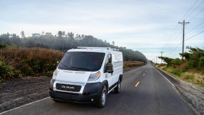 A white 2021 Ram ProMaster van on a rural two-lane road