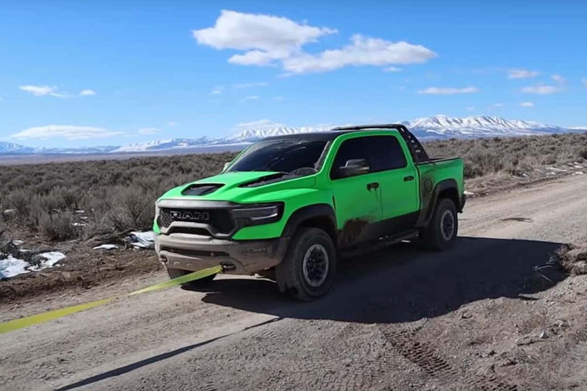 lime-green Ram TRX getting pulled off the trail after a break down