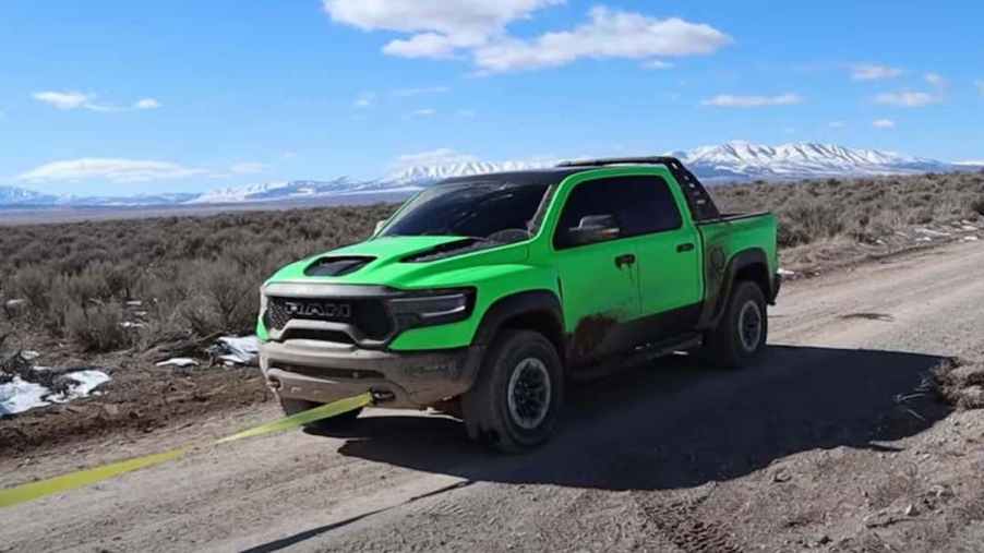 lime-green Ram TRX getting pulled off the trail after a break down