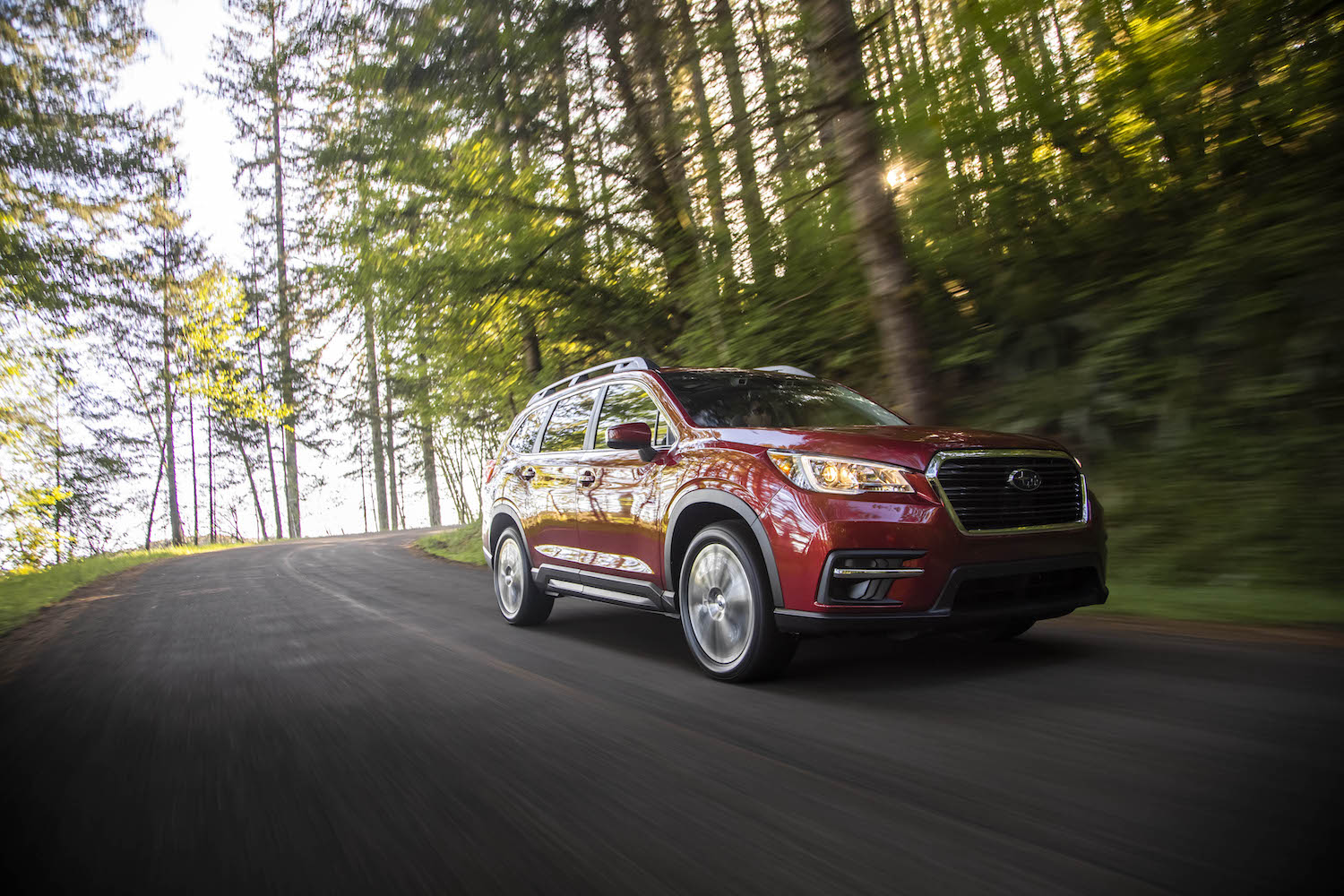 2021 Subaru Ascent rounding a bend in the woods.