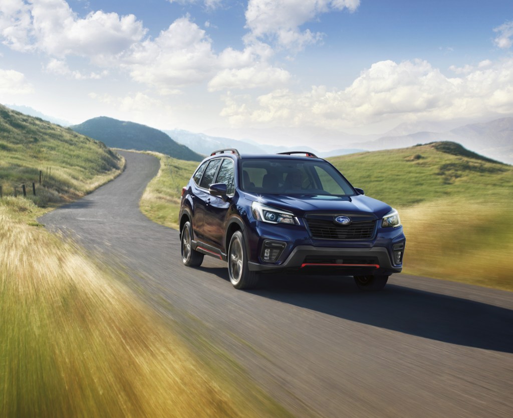A black 2021 Subaru Forester driving down a country road