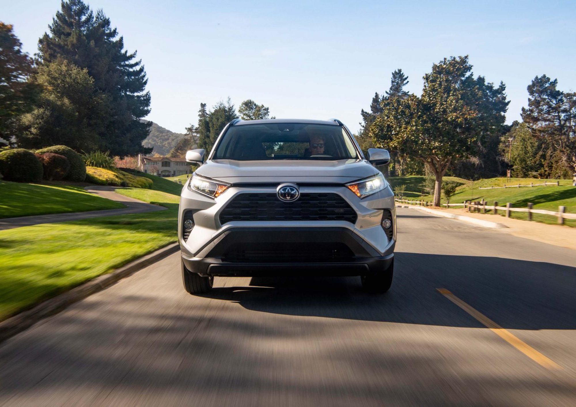 A silver 2021 Toyota RAV4 XLE front-wheel-drive compact crossover SUV on a suburban street