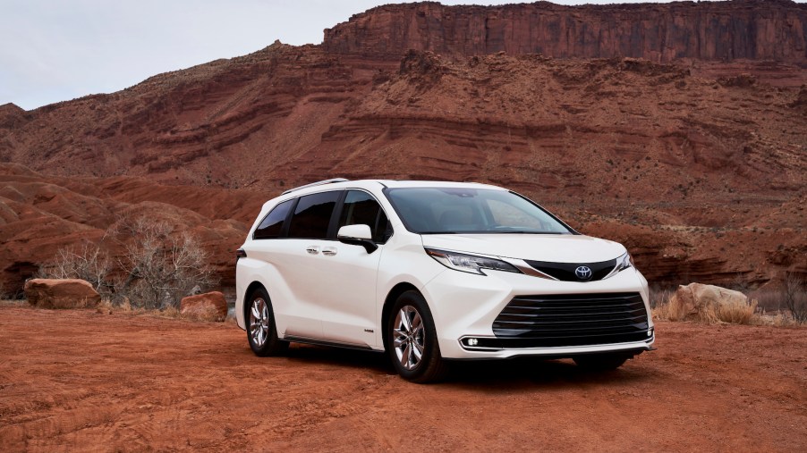 A white 2021 Toyota Sienna Limited minivan parked on red dirt in front of a butte