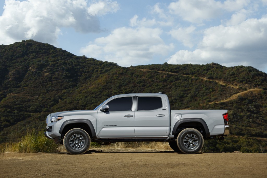 A silver 2021 Toyota Tacoma Trail Edition on display in front of a mountain range