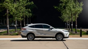 A white 2021 Toyota Venza XLE parked next to a grassy area with young trees