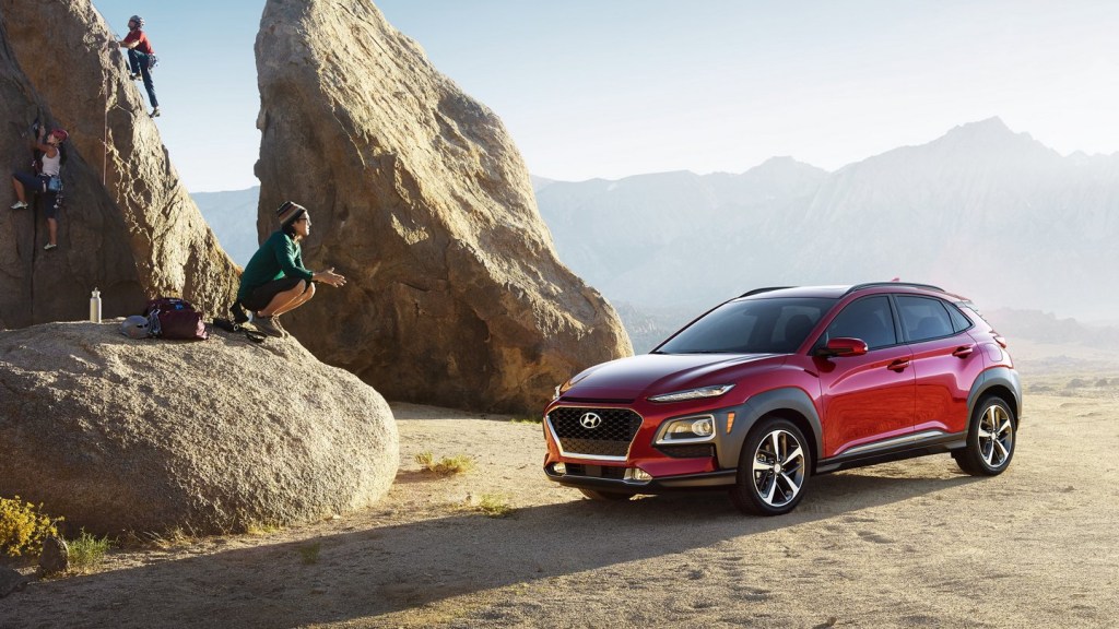A red 2021 Hyundai Kona parked on the edge of a rocky cliff